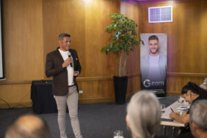 Muž přednáší na konferenci před pozorným publikem.