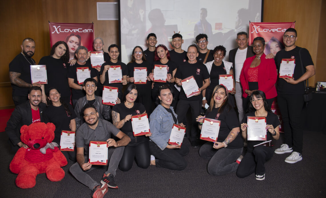 Skupina lidí s certifikáty a červeným medvědem.