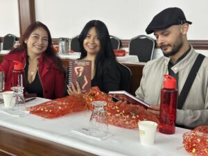Three people in a workshop with promotional notebooks