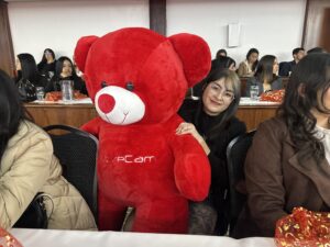 A woman hugging a giant red teddy bear
