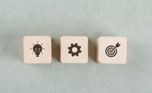 Lightbulb, gear, target icons on wooden blocks.